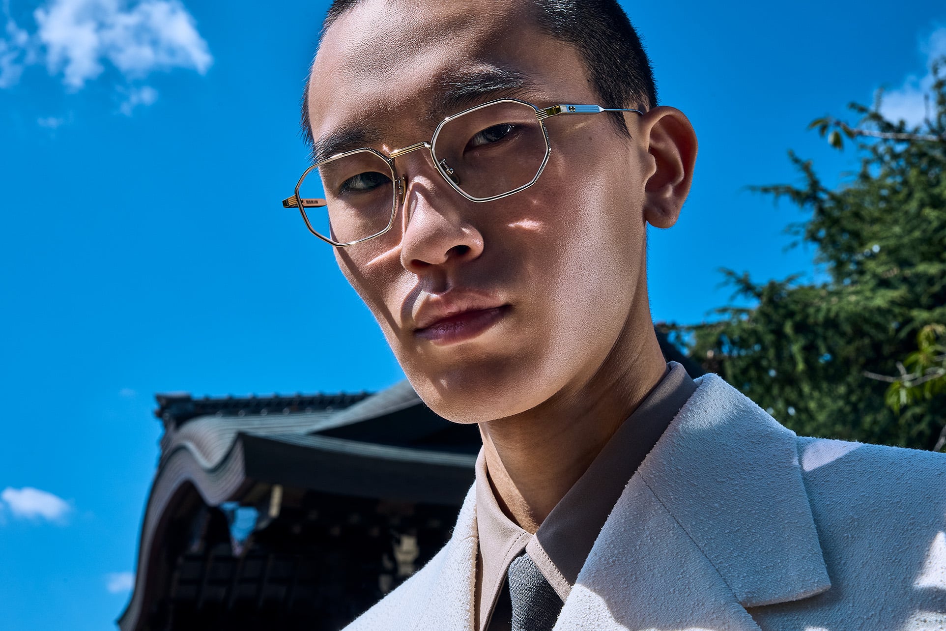 Man wearing Cutler and Gross optical frames against a blue sky