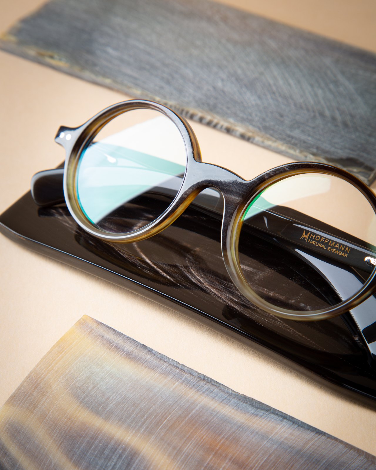 A round Hoffmann frame resting on planks of raw horn and wood, showing the natural materials the frames are cut from.