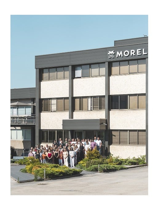 The Morel eyewear atelier building in Morbier, in the Haut-Jura region of France, with the Morel team gathered outside.