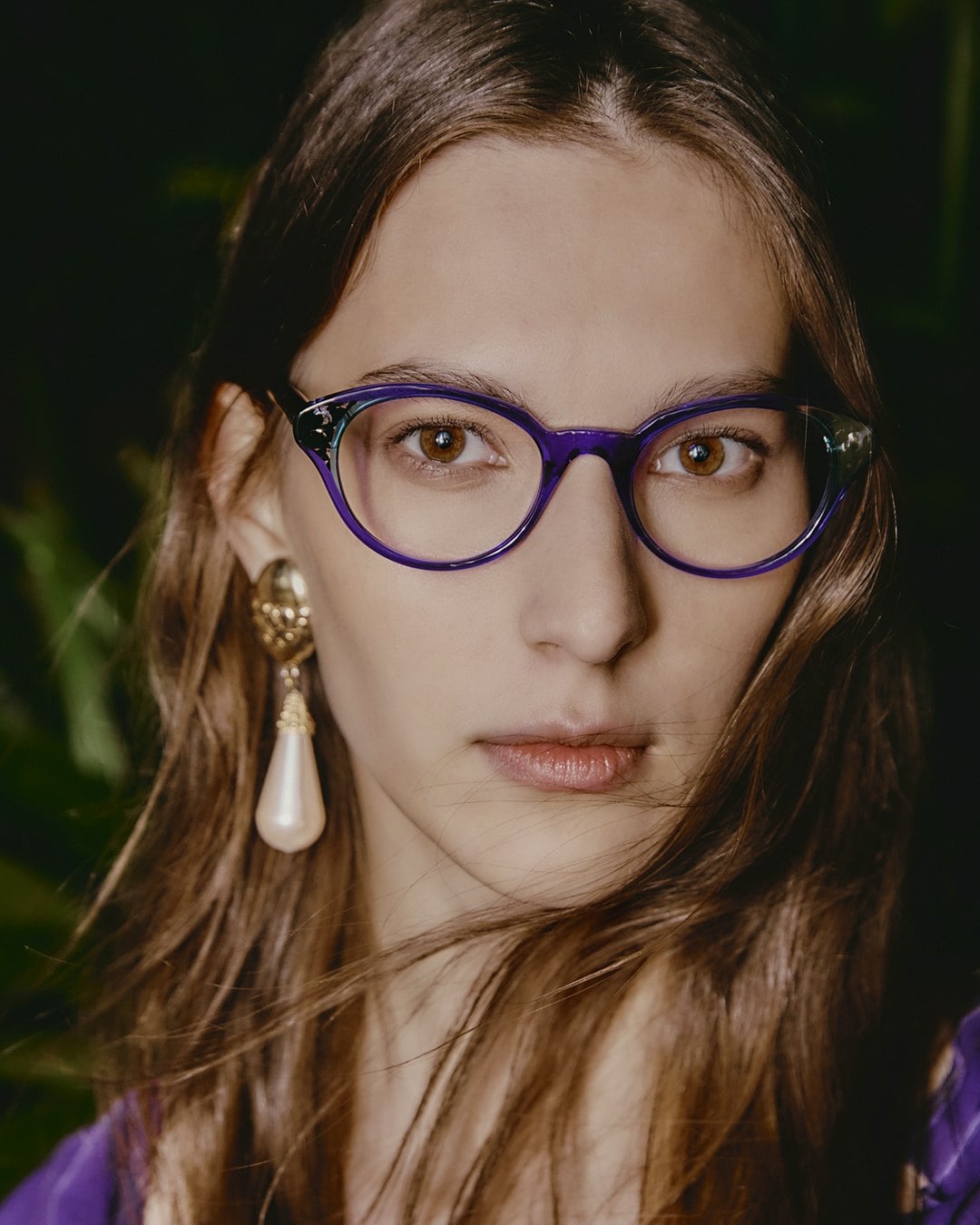 A model wearing an Onirico optical frame in translucent blue and violet acetate, the color visible through the material.