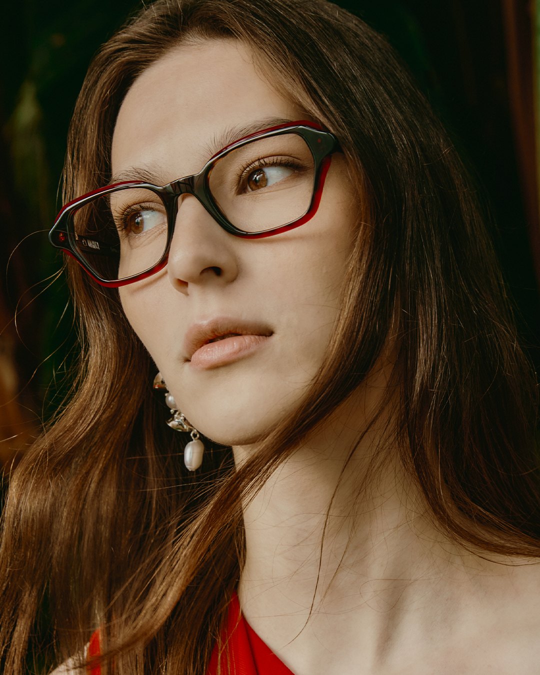 A model wearing an Onirico optical frame in warm tortoise and red Italian acetate.